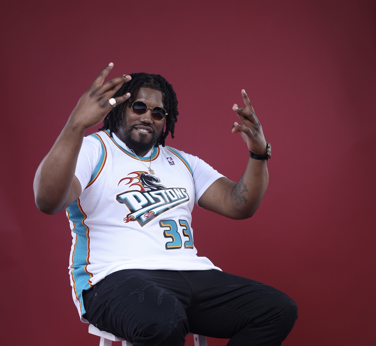 Chris Lanard seated against a deep red studio background